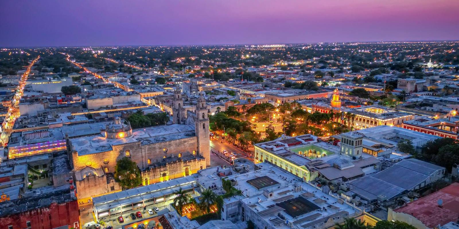 Stunning aerial panorama of Mérida, Mexico at twilight with vibrant city lights.