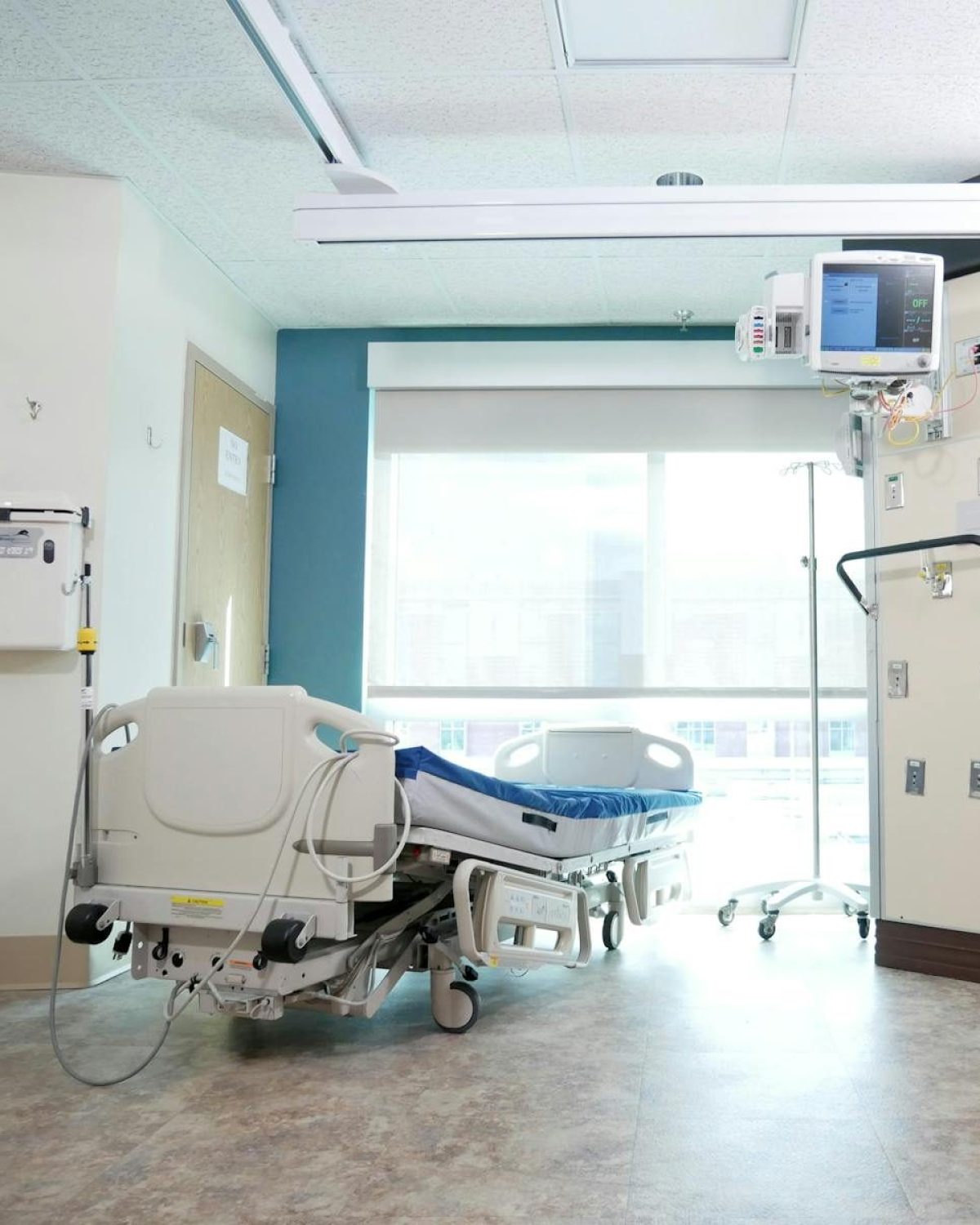 A well-equipped hospital room with a bed and advanced medical equipment.