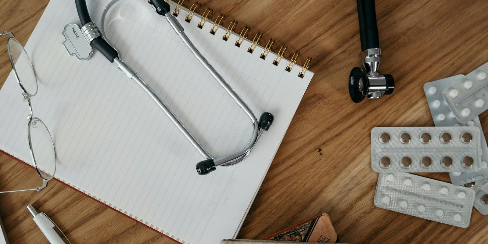 Flat lay of medical tools and supplies on a wooden desk surface.