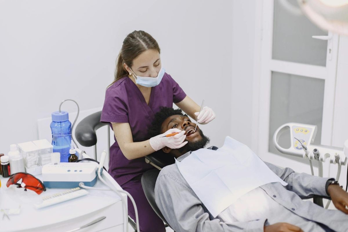 A dentist conducts a dental checkup on a patient in a clinic setting.