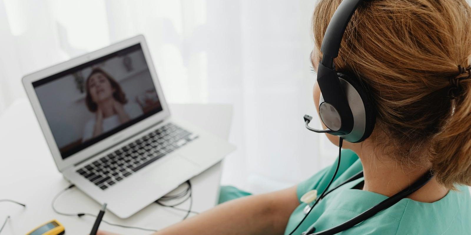 Medical professional consulting a patient online via laptop for telehealth services.