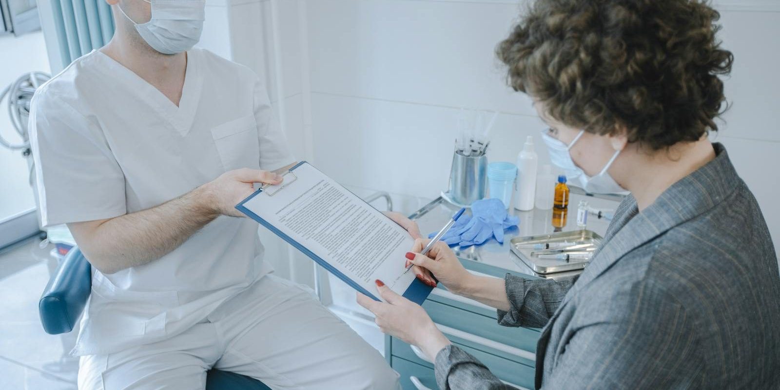 A medical professional and patient reviewing documents in a clinic setting.